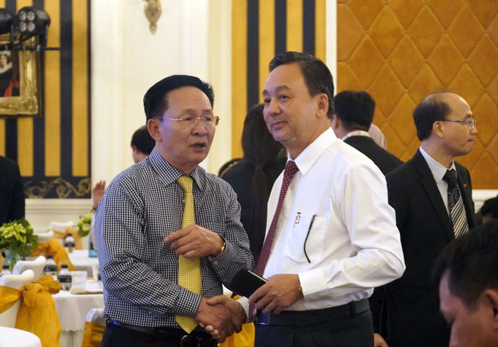 Ông Phạm Văn Triêm (phải) trao đổi với một doanh nghiệp tại buổi gặp mặt.