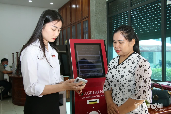 Nhân viên Agribank chi nhánh Đồng Nai (phường Trấn Biên) hướng dẫn khách hàng sử dụng tiện ích trên ứng dụng ngân hàng số